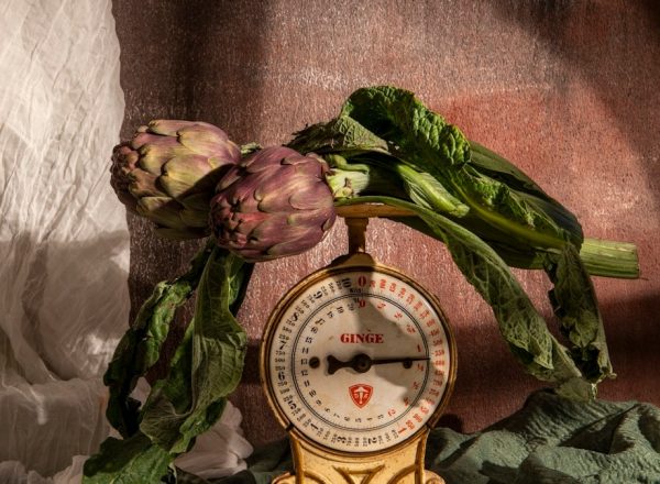 Artichokes rest upon an old-fashioned scale.
